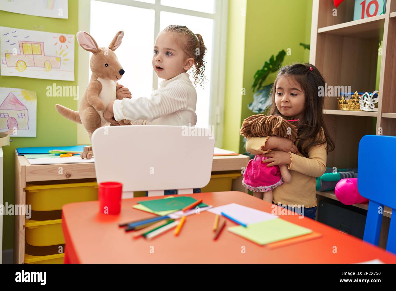 Adorable girls holding dolls at kindergarten Stock Photo Alamy