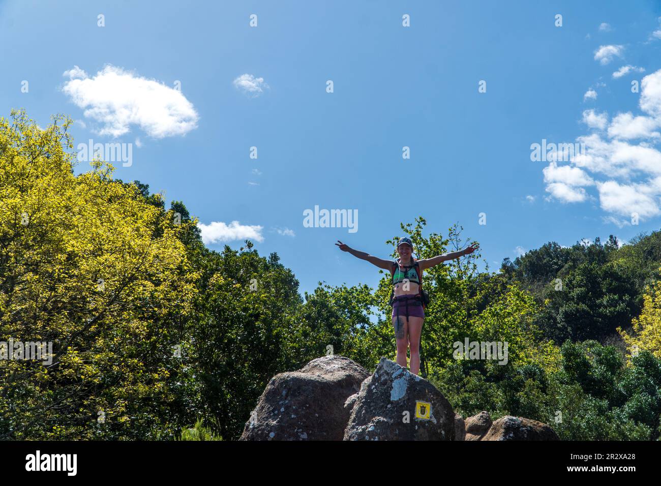 Young lady hiker with backpack enjoying sunrise from top of a mountain ...