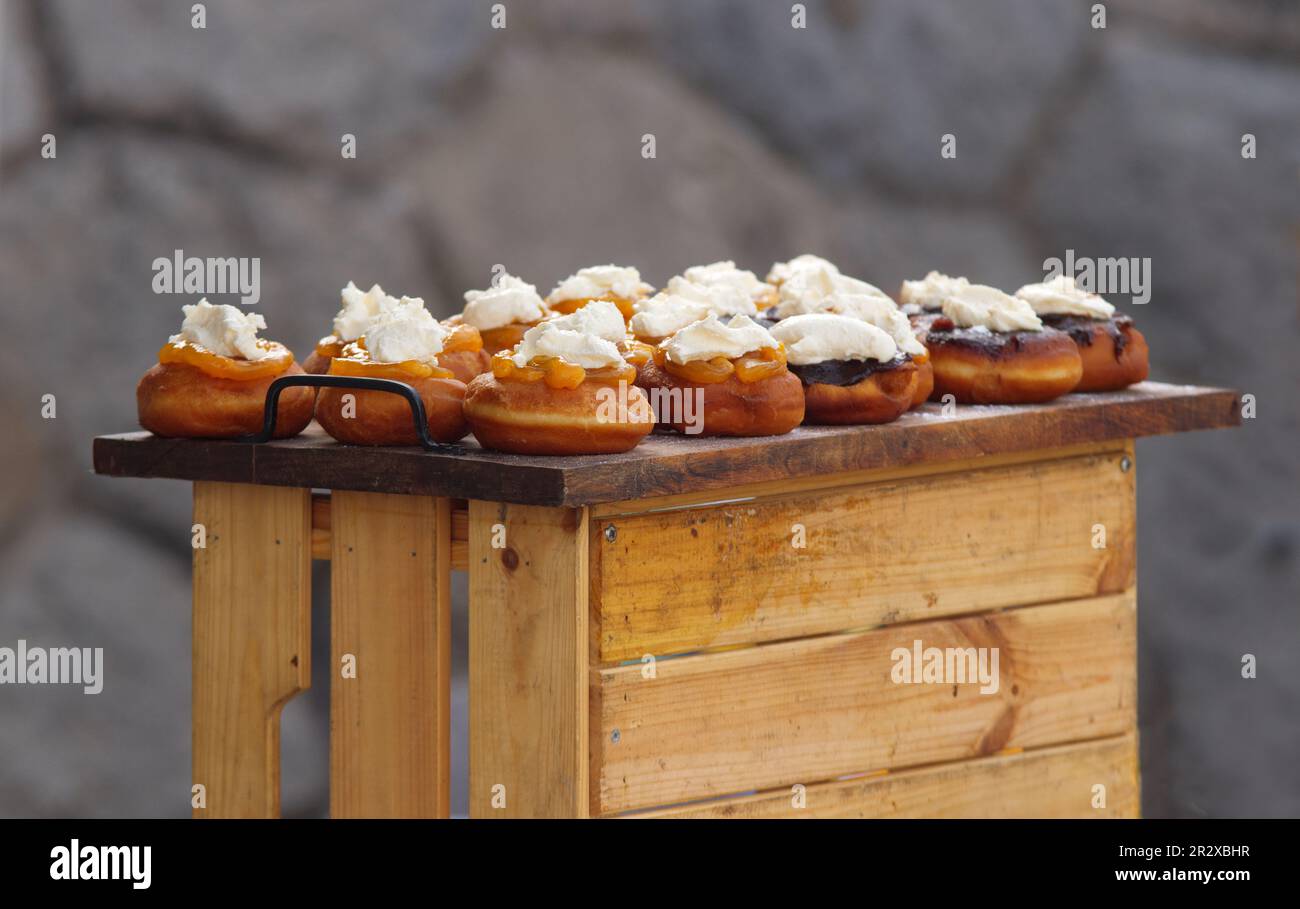 Bavarian donuts or muffins, deep fried doughnuts with fruit jam and farmers cream cheese displayed at the stall at farmers street food market in Pragu Stock Photo