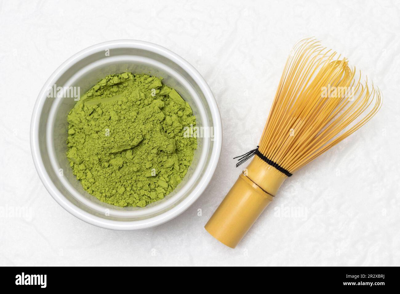 Green matcha powder in a bowl. Chasen whisk for making matcha green tea