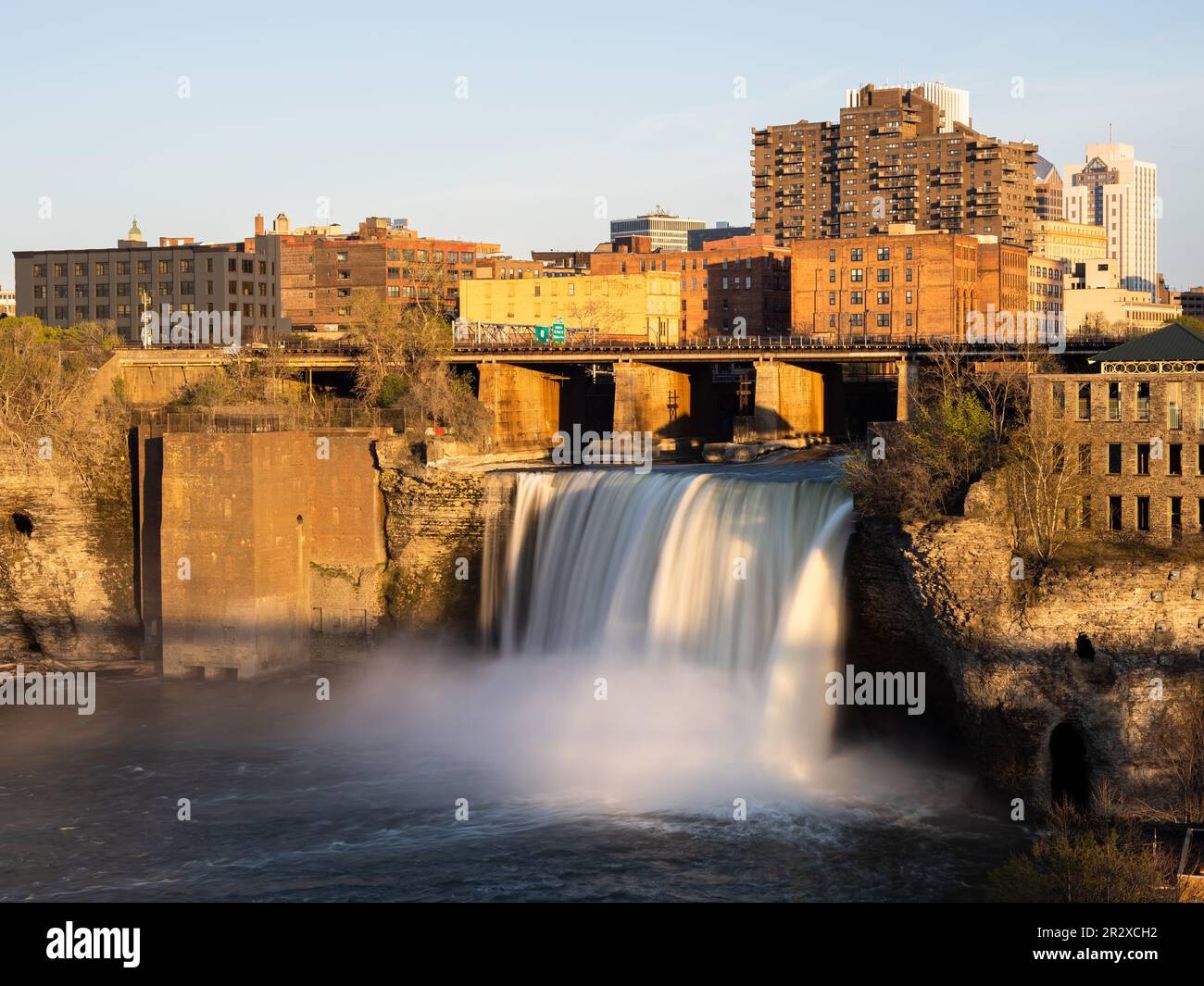 Silky, smooth water and golden sunset at High Falls in Rochester, Upstate New York State. Stock Photo