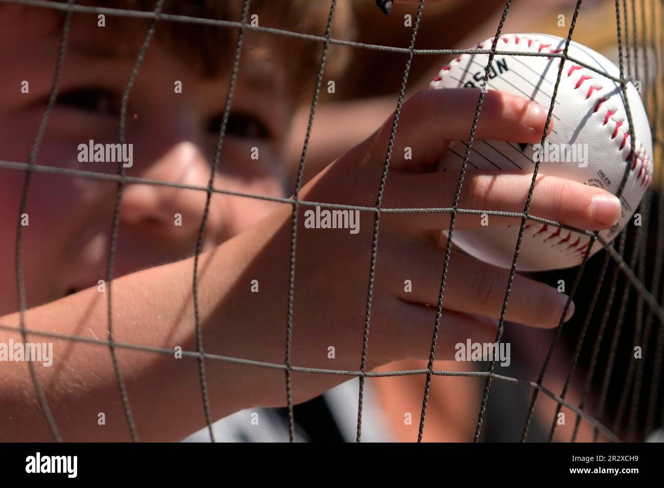 A baseball fan holds a ball as he waits to get an autograph from Chicago  White Sox's Jake Burger before a baseball game between the Kansas City  Royals and the Chicago White