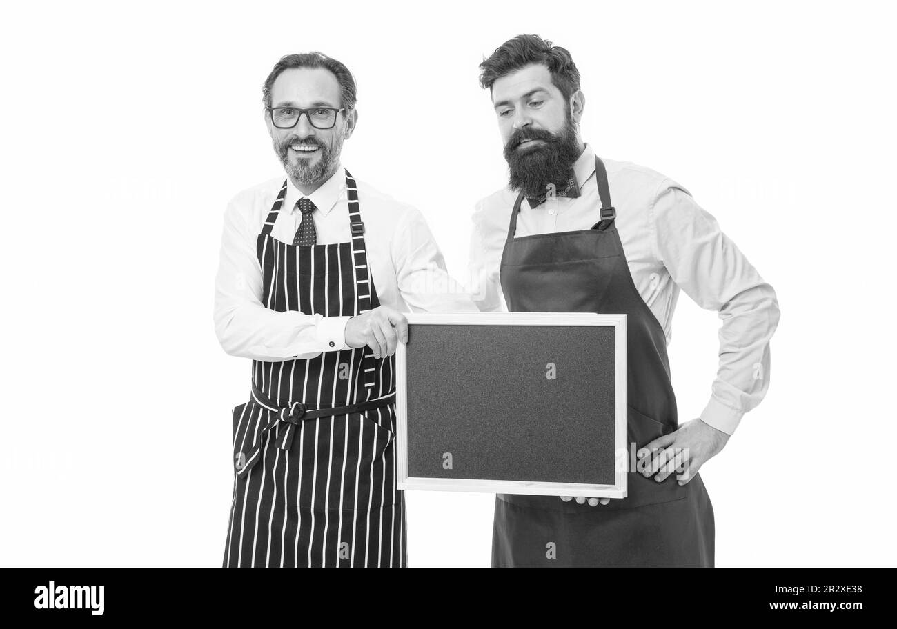 Hiring staff. Men bearded hipster informing you. Men bearded bartender or cook in apron hold blank chalkboard. Workers wanted. Bartender with Stock Photo