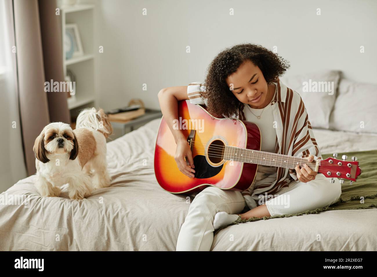 Minimal portrait of black young woman playing acoustic guitar and ...