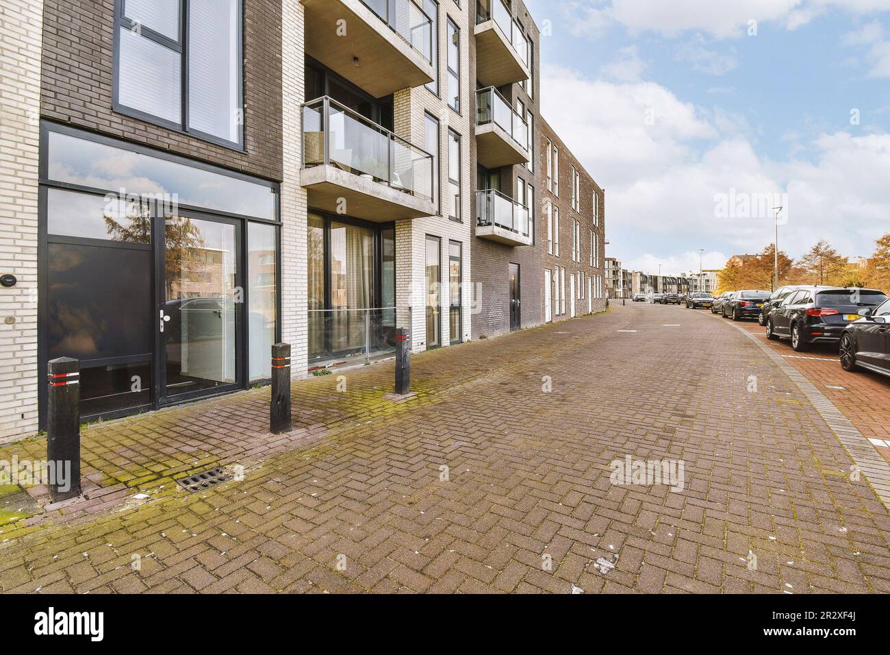 a city street with cars parked on the side and buildings in the back ...