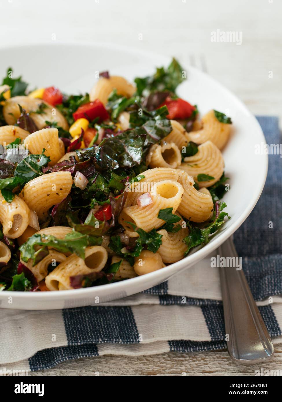 Bowl with a vegan home made kale pasta salad using the heirloom variety 'Red Russian'. Stock Photo