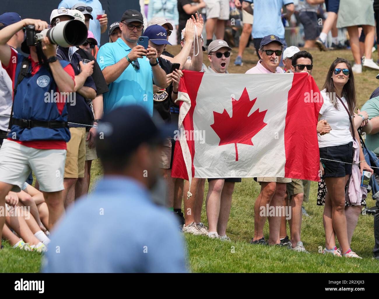 Rochester, United States. 21st May, 2023. A spectator holds up the Canadian flag as Corey Conners of Canada walks down the 1st fairway during the final round of the 2023 PGA Championship at Oak Hill Country Club in Rochester, New York on Sunday, May 21, 2023. Photo by Aaron Josefczyk/UPI Credit: UPI/Alamy Live News Stock Photo