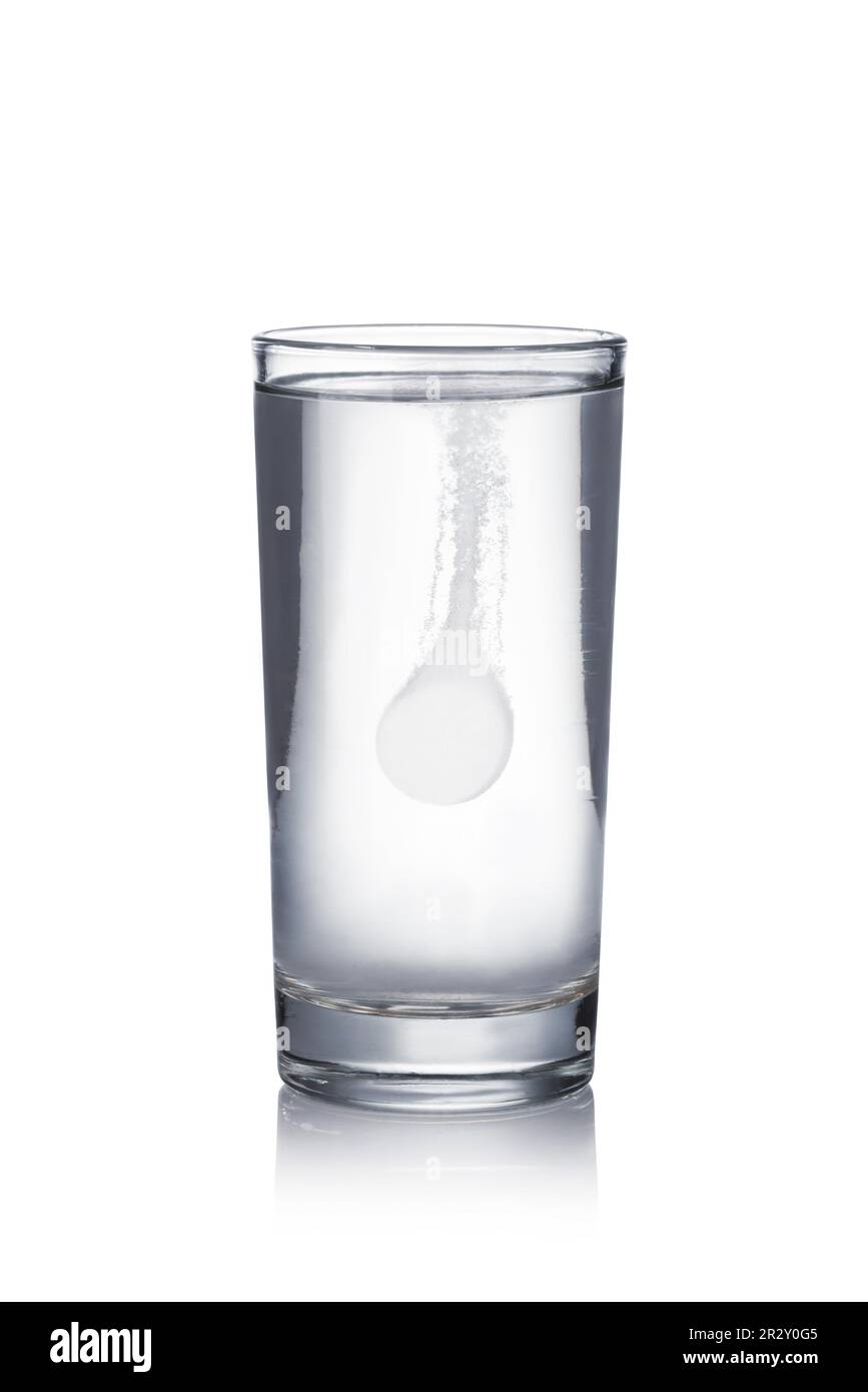 Glass with effervescent tablet in water with bubbles on white background Stock Photo