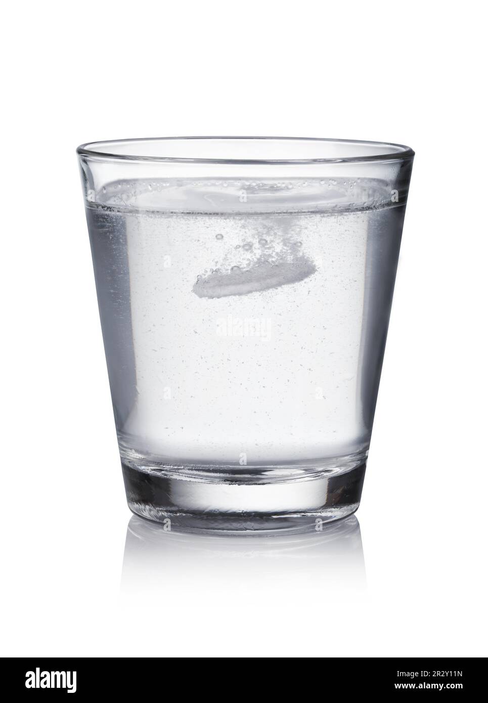 Glass with effervescent tablet in water with bubbles on white