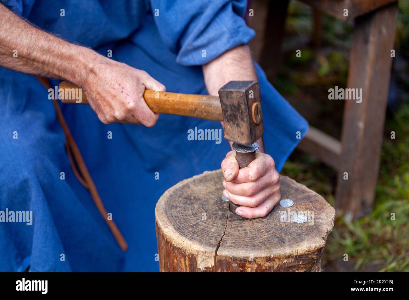 Medieval minter minting a coin with his hammer on a log Stock Photo Alamy