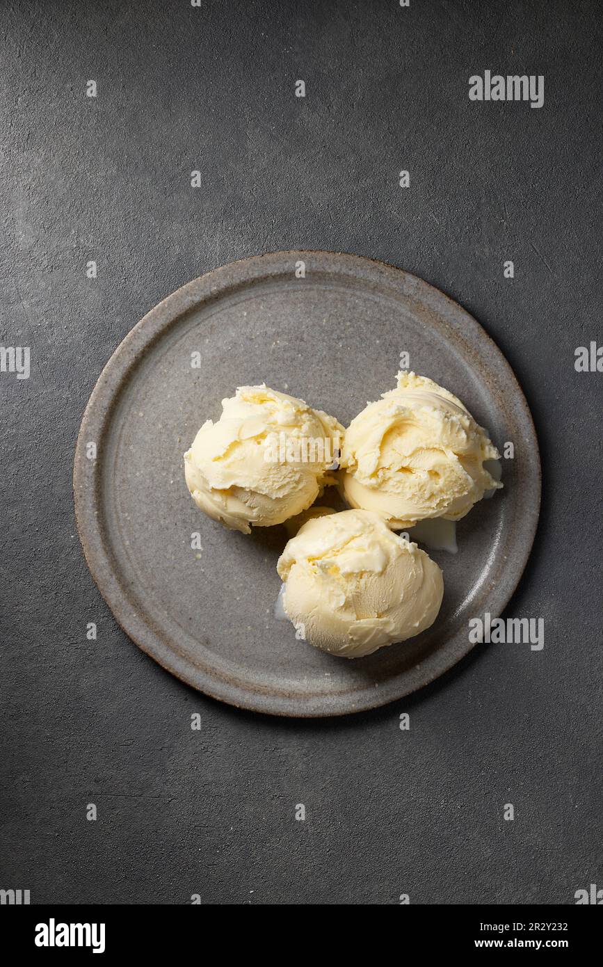 three vanilla ice cream balls on grey plate, top view Stock Photo
