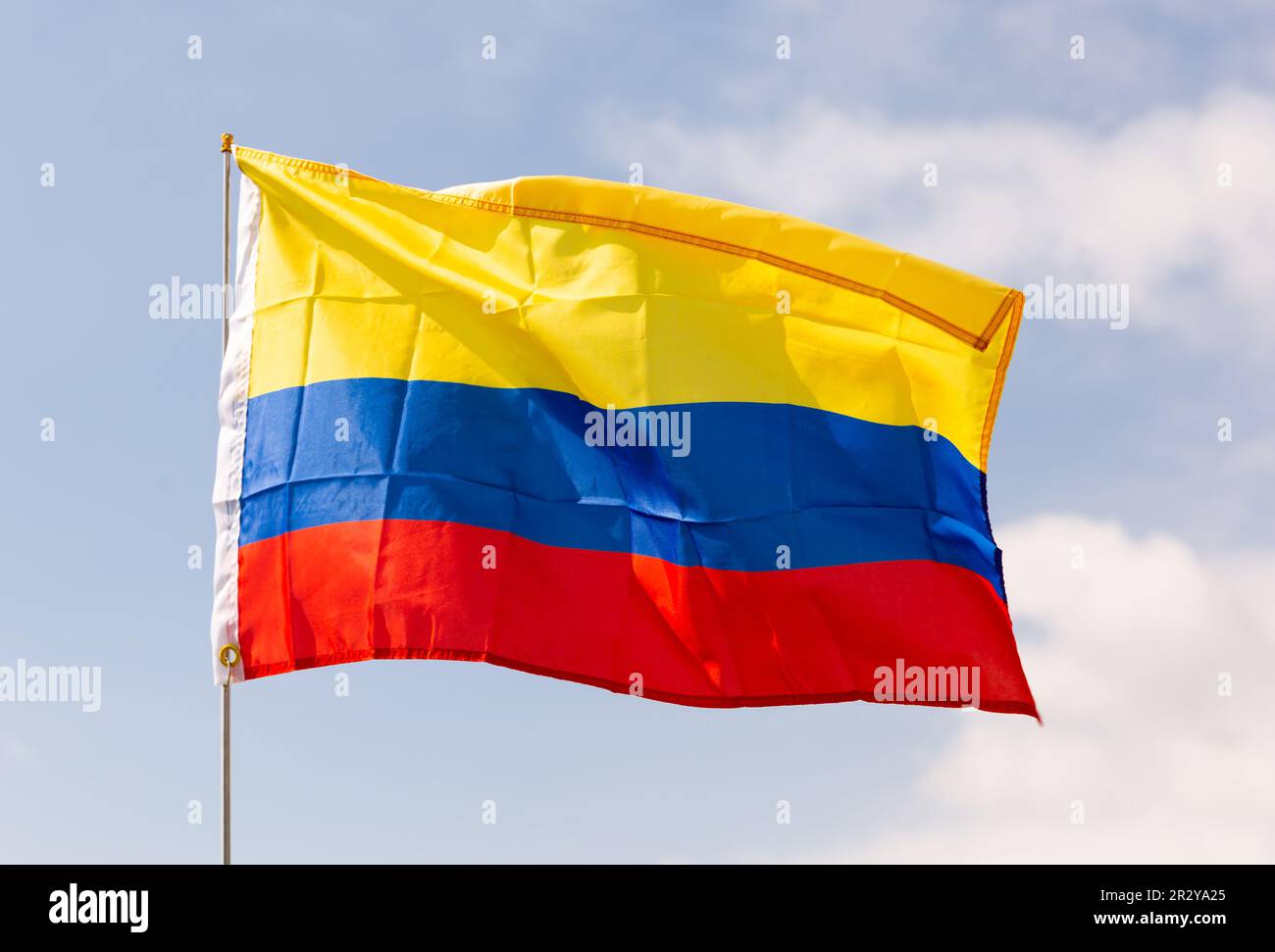 National flag of Colombia waving on flagpole against blue sky Stock Photo