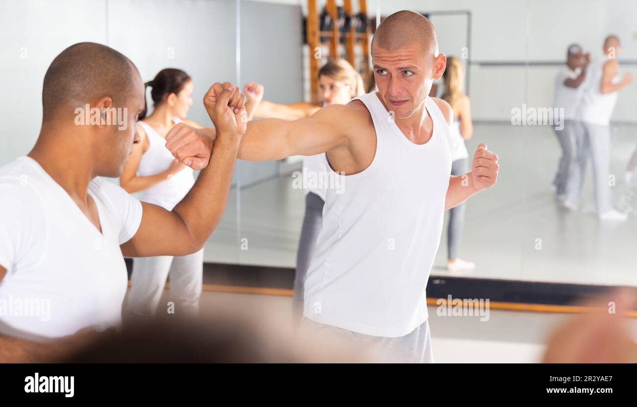 Two men practicing self defense techniques in gym Stock Photo - Alamy