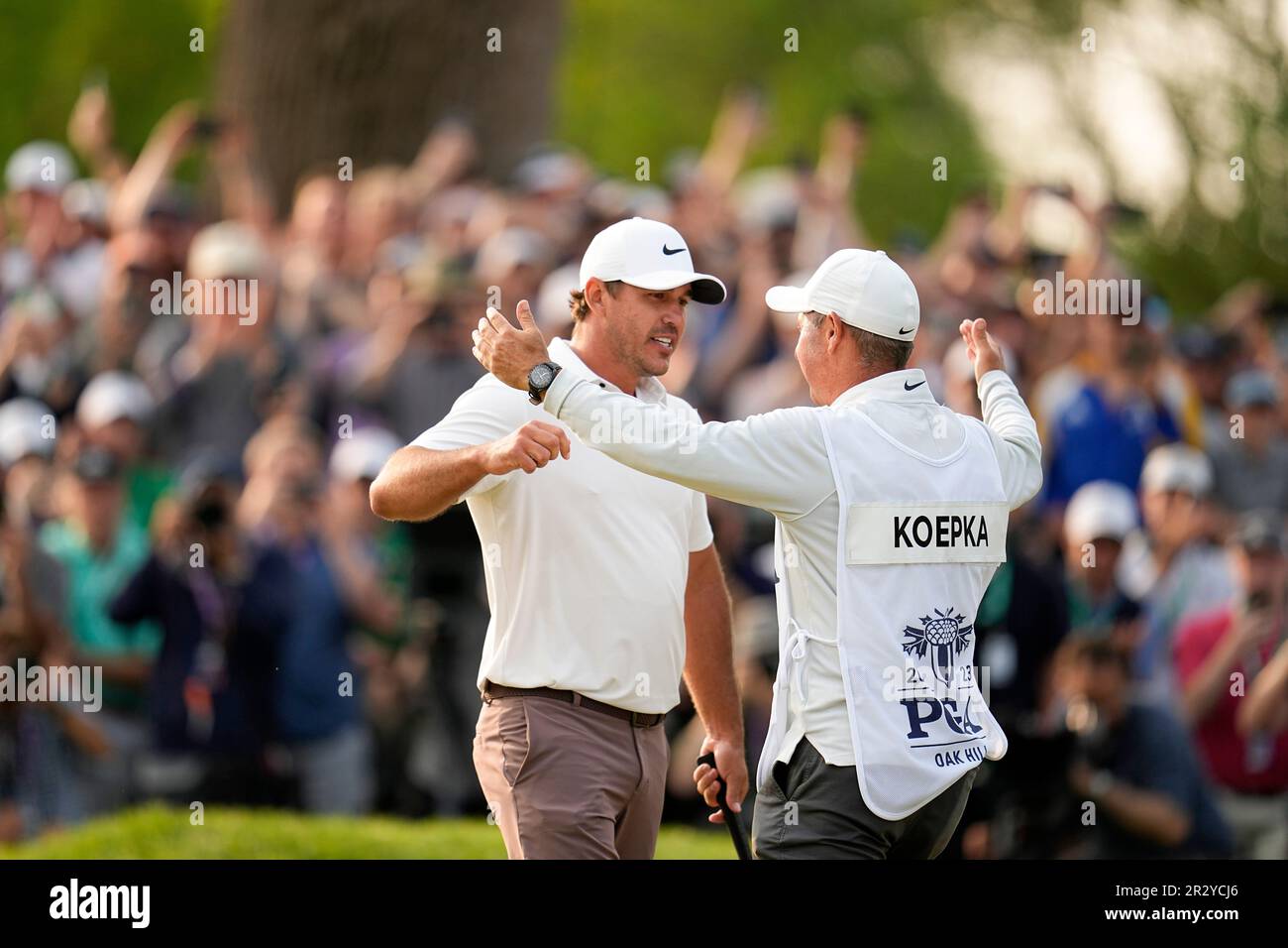Brooks Koepka celebrates with his caddie Ricky Elliott after winning