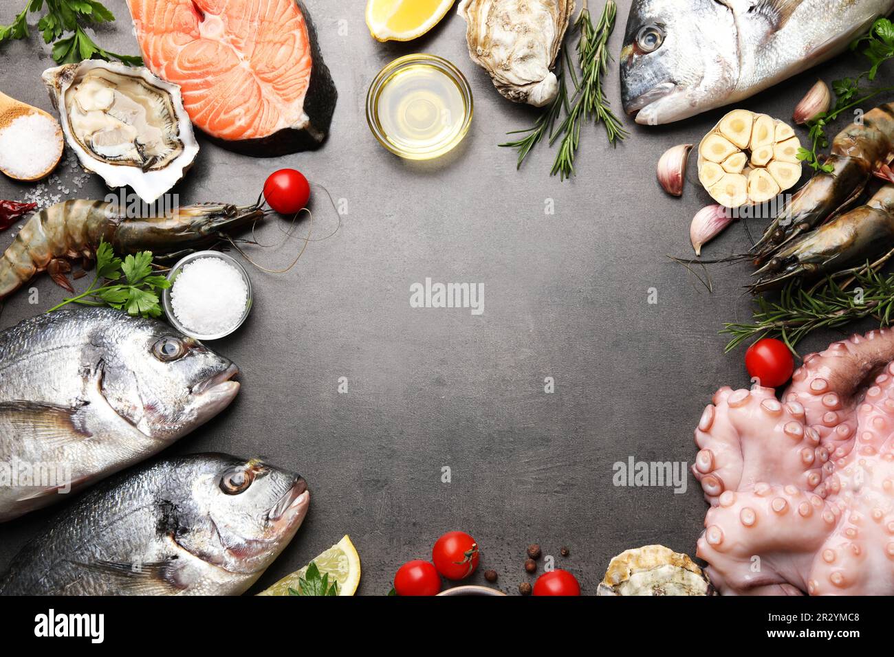 Frame of fresh raw dorado fish and different seafood on grey table, top ...