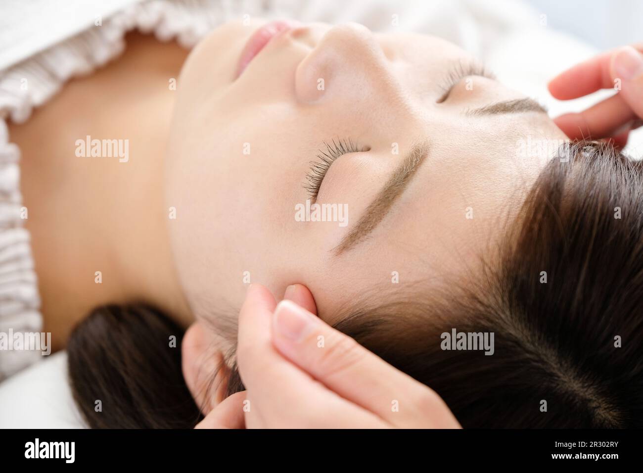 A woman receiving temple shiatsu at acupuncture Stock Photo