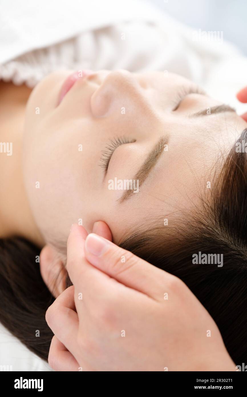 A woman receiving temple shiatsu at acupuncture Stock Photo