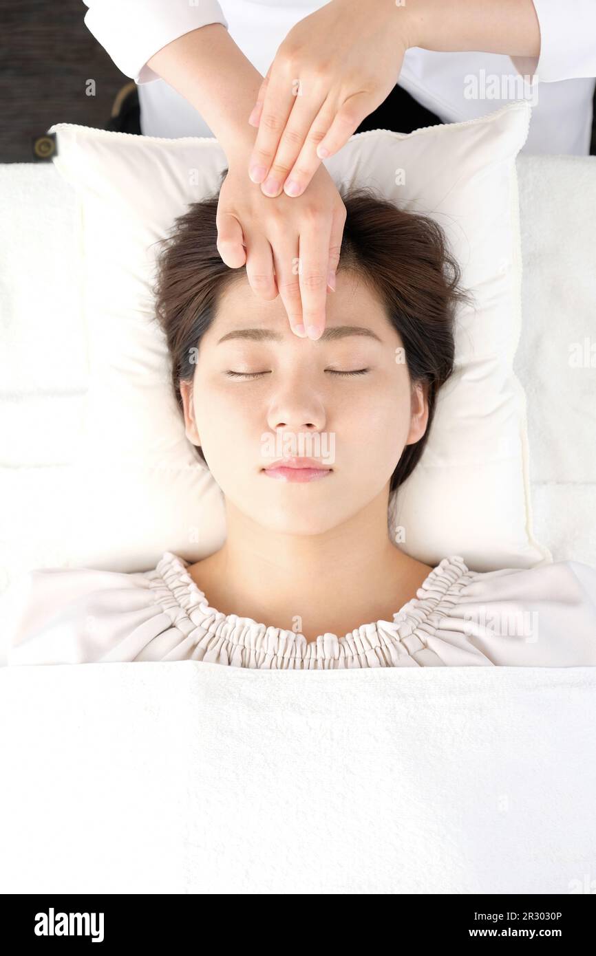 Woman receiving acupressure between the eyes at an acupuncture clinic ...