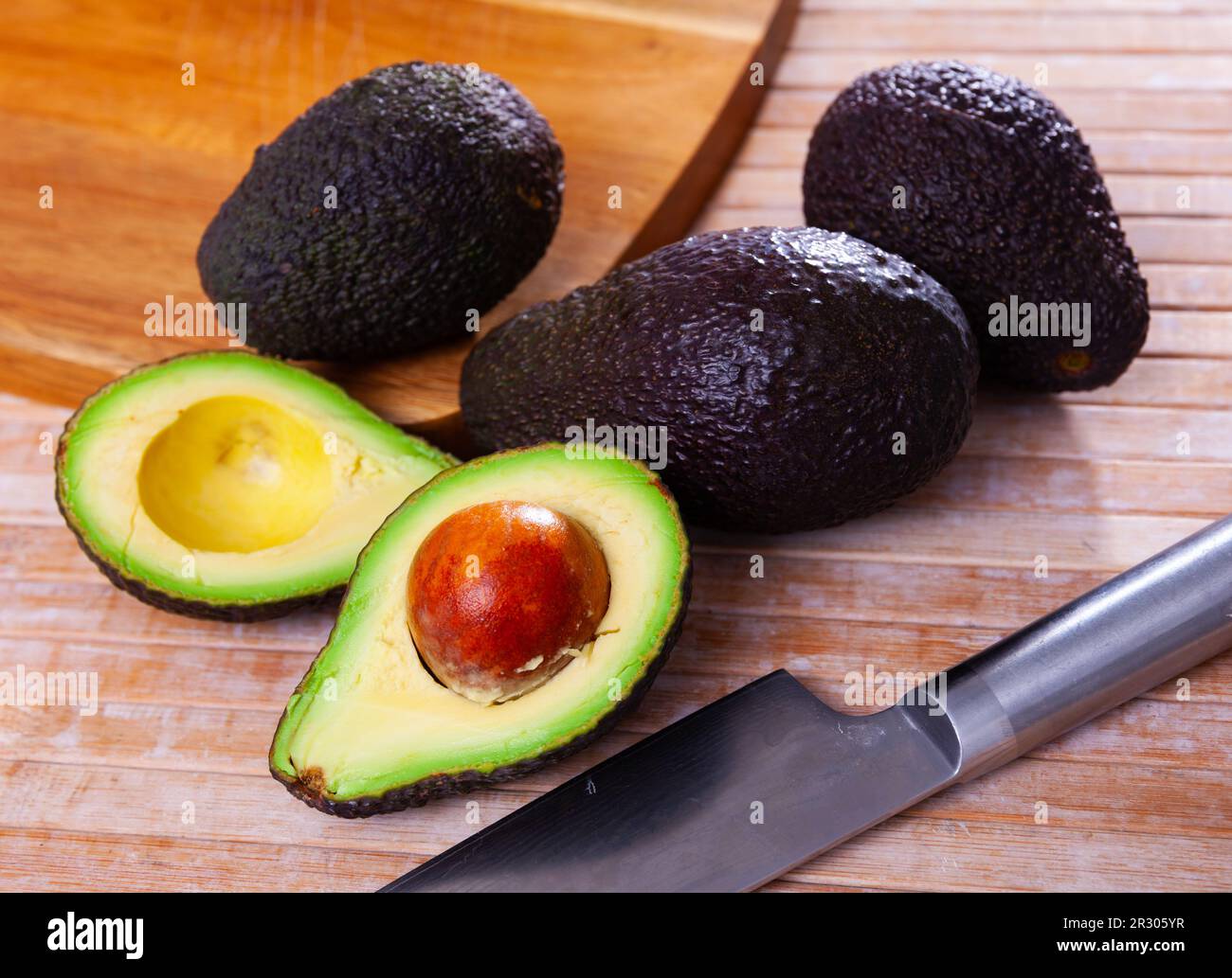 https://c8.alamy.com/comp/2R305YR/whole-and-halved-avocados-on-wooden-cutting-board-2R305YR.jpg