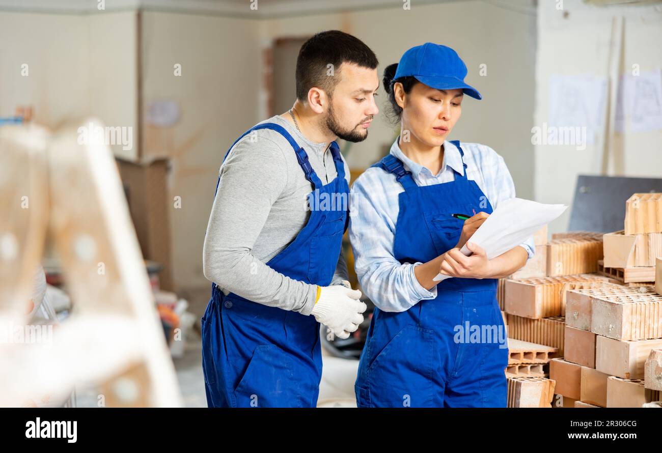 Woman and man repairers talking about documentation Stock Photo