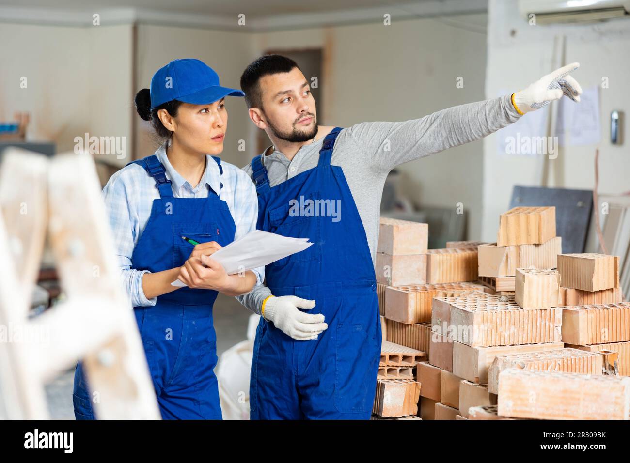 Woman and man repairers talking about documentation Stock Photo