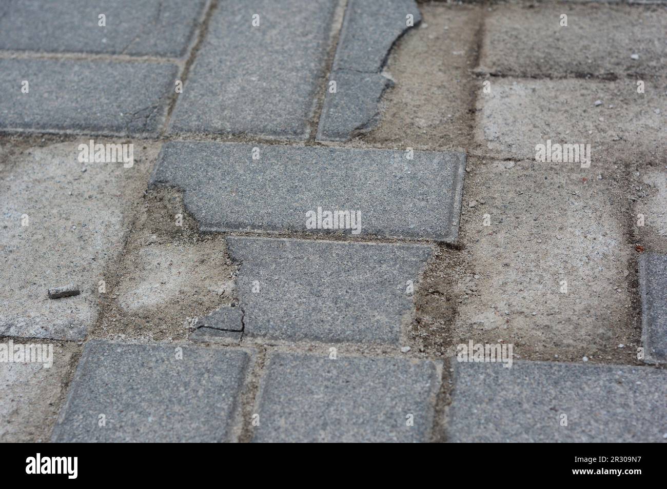 Broken and cracked paving stones. Damaged pavement need repair Stock
