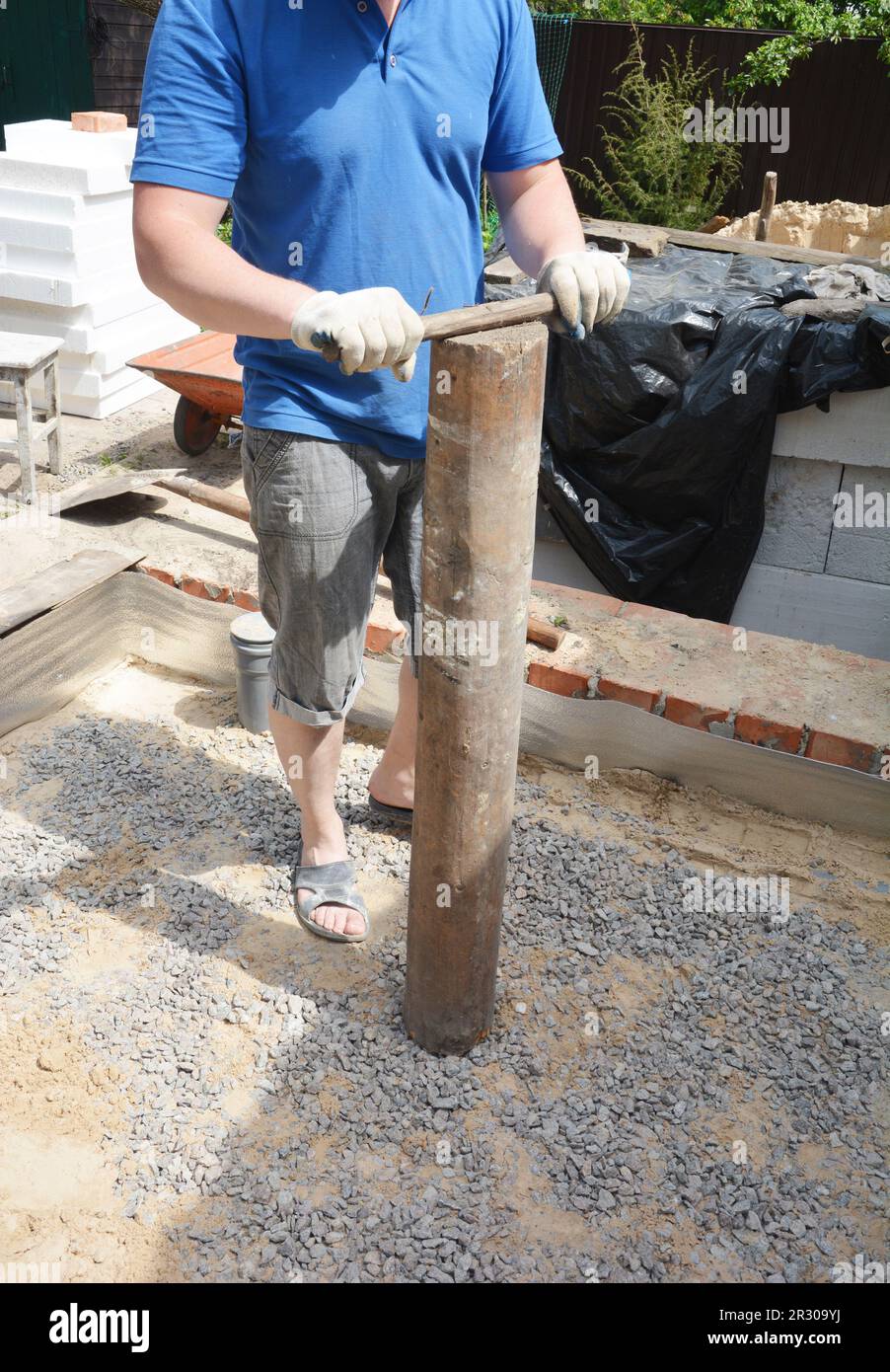 The builder tamping the foundation in the house before pouring concrete floor. Tamping next to