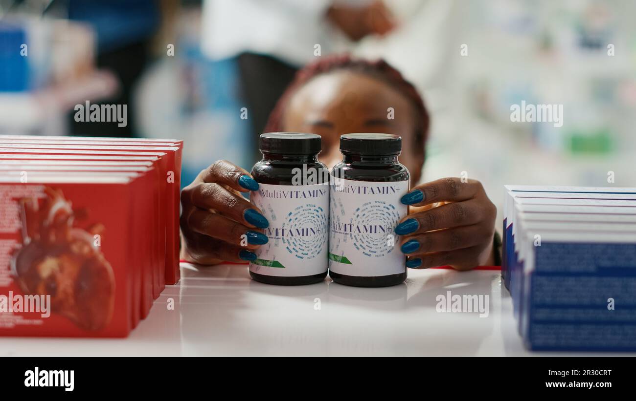 Woman organizing bottles of medicine on shelves Stock Photo Alamy
