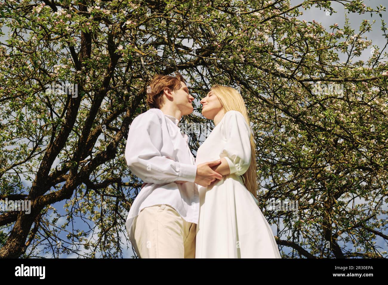 Low angle view at happy couple in love hug each other Stock Photo