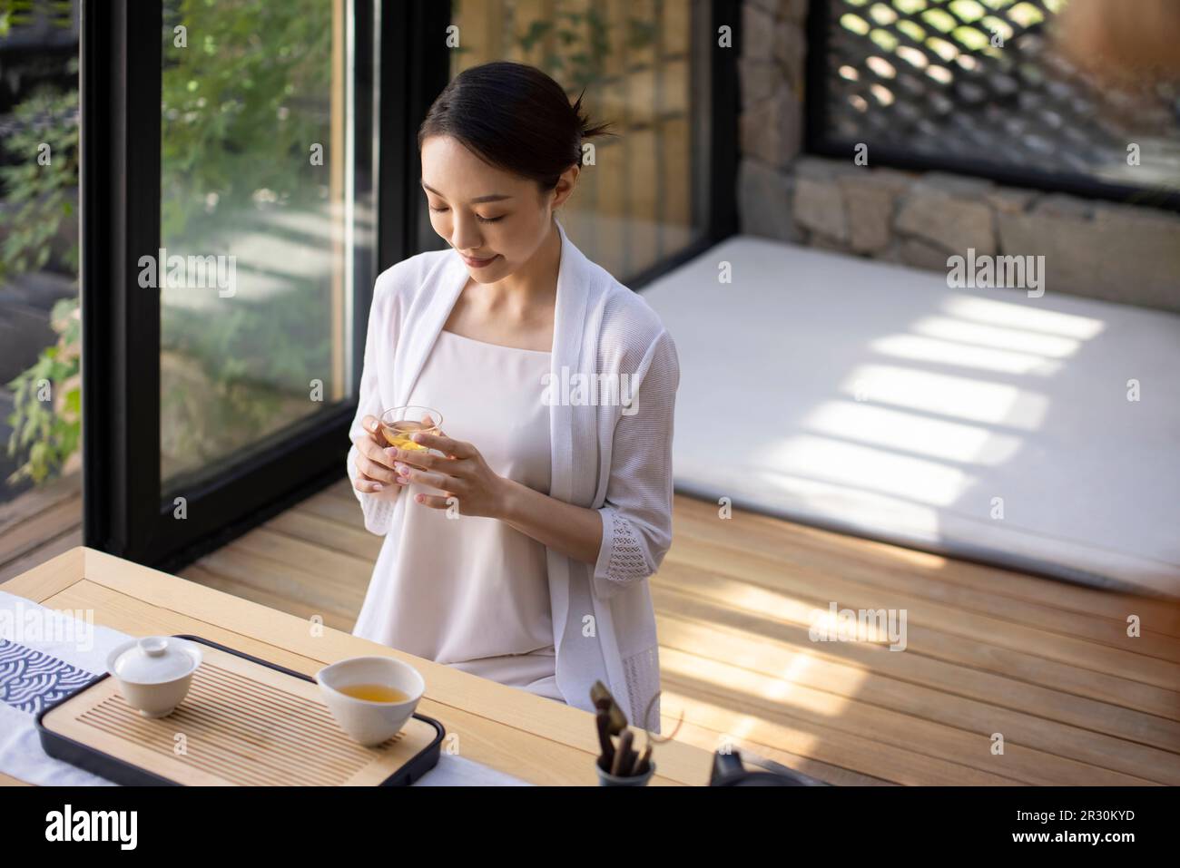 Elegant young Chinese woman drinking tea in tea room Stock Photo - Alamy