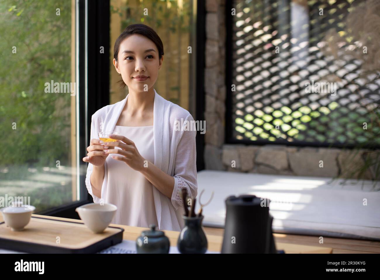 Elegant young Chinese woman drinking tea in tea room Stock Photo - Alamy