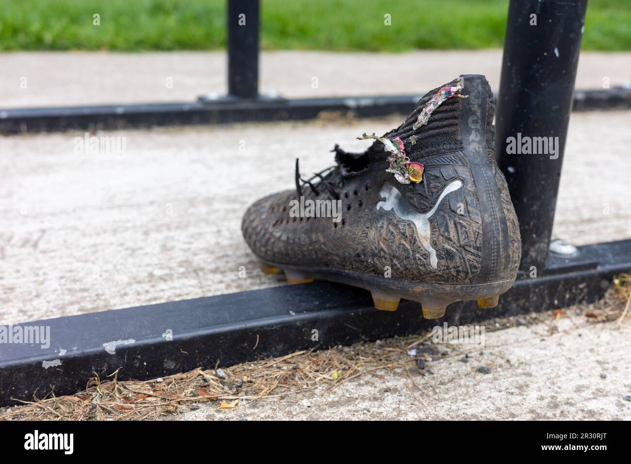 Single Puma football boot left at the training ground Stock Photo