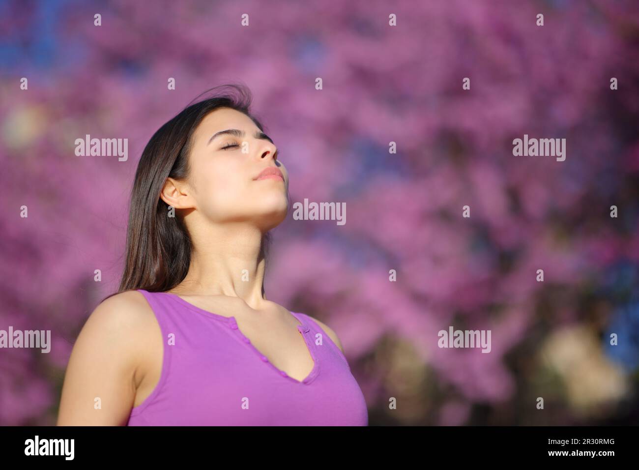 Relaxed woman breathing fresh air on violet in a park Stock Photo - Alamy