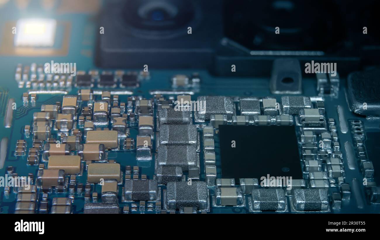 Macro shot of the smartphone's main board with the camera unit and CPU  in the foreground Stock Photo