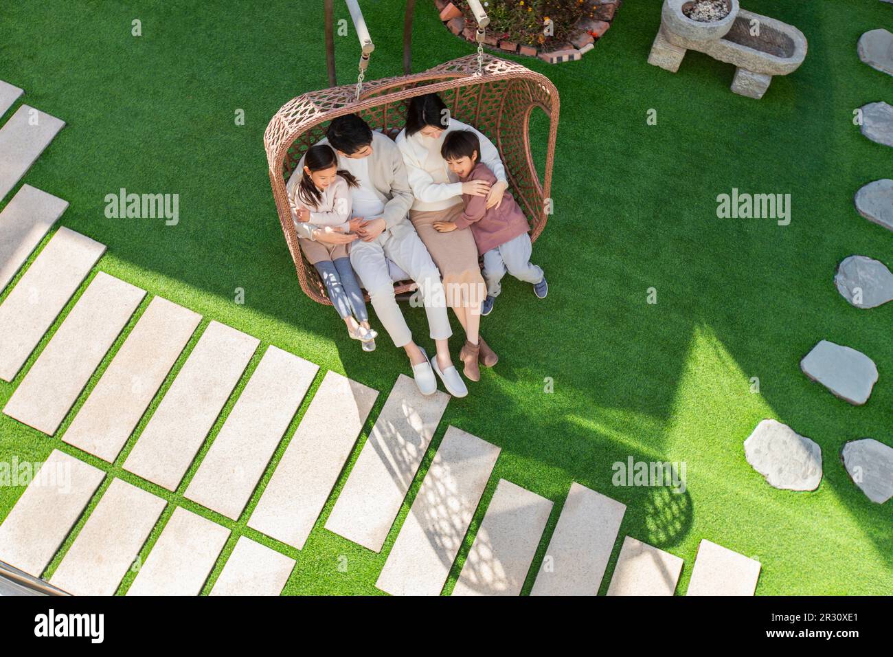 Happy young Chinese family relaxing on hanging-chair Stock Photo - Alamy