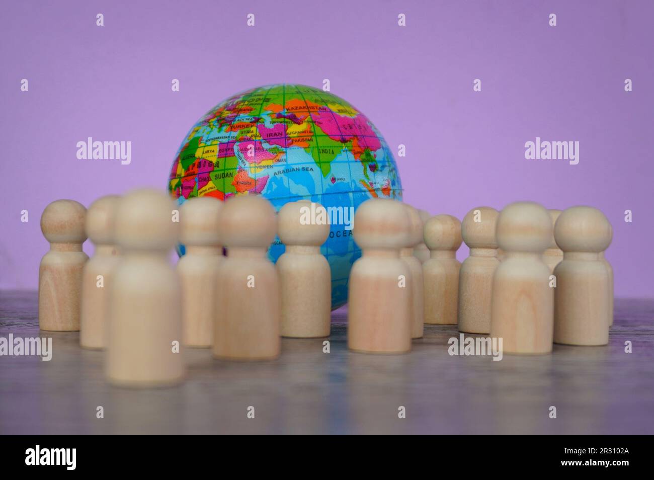 Wooden dolls and earth globe. World Population Day concept Stock Photo