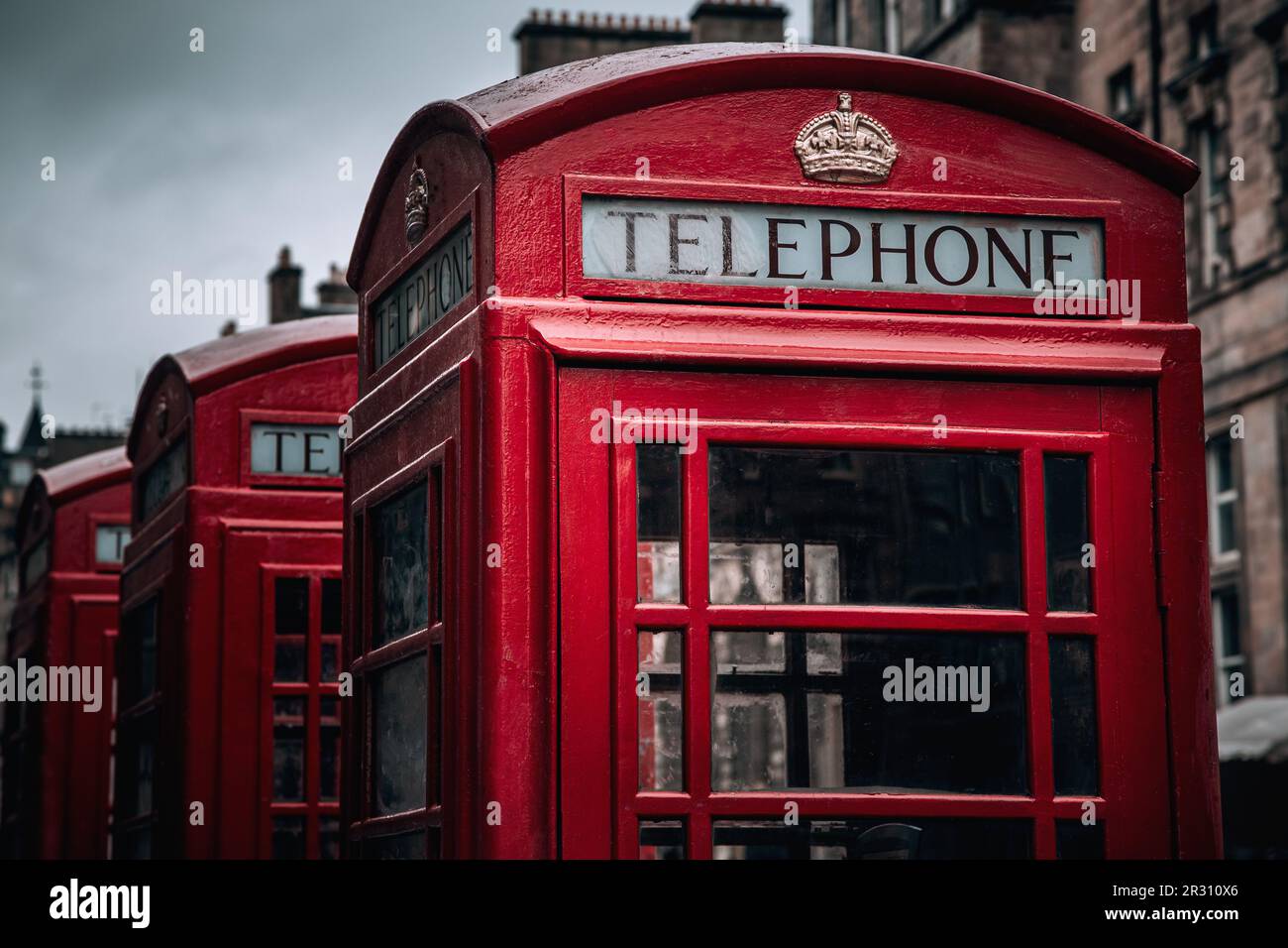 A row of classic British phone boxes on The Royal Mile, Edinburgh, Scotland. Retro effect close up in dark and moody tones. Stock Photo