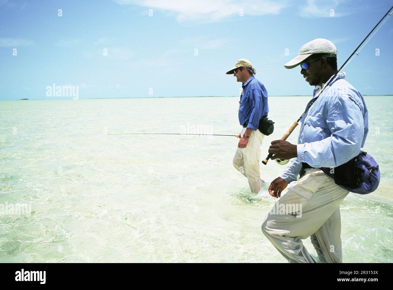 Two fly-fishermen wade the saltwater flats of the Bahamas Stock Photo -  Alamy