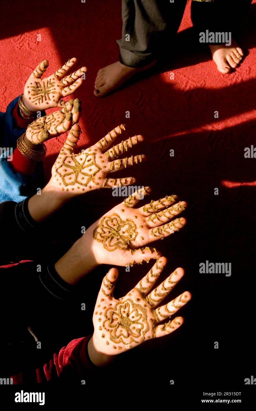 Three girls put their hennaed hands in the sun to dry. Stock Photo