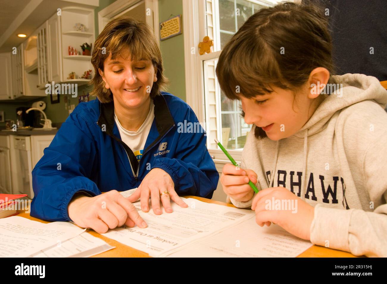 A mother helps her ten-year-old daughter with her homework. Stock Photo
