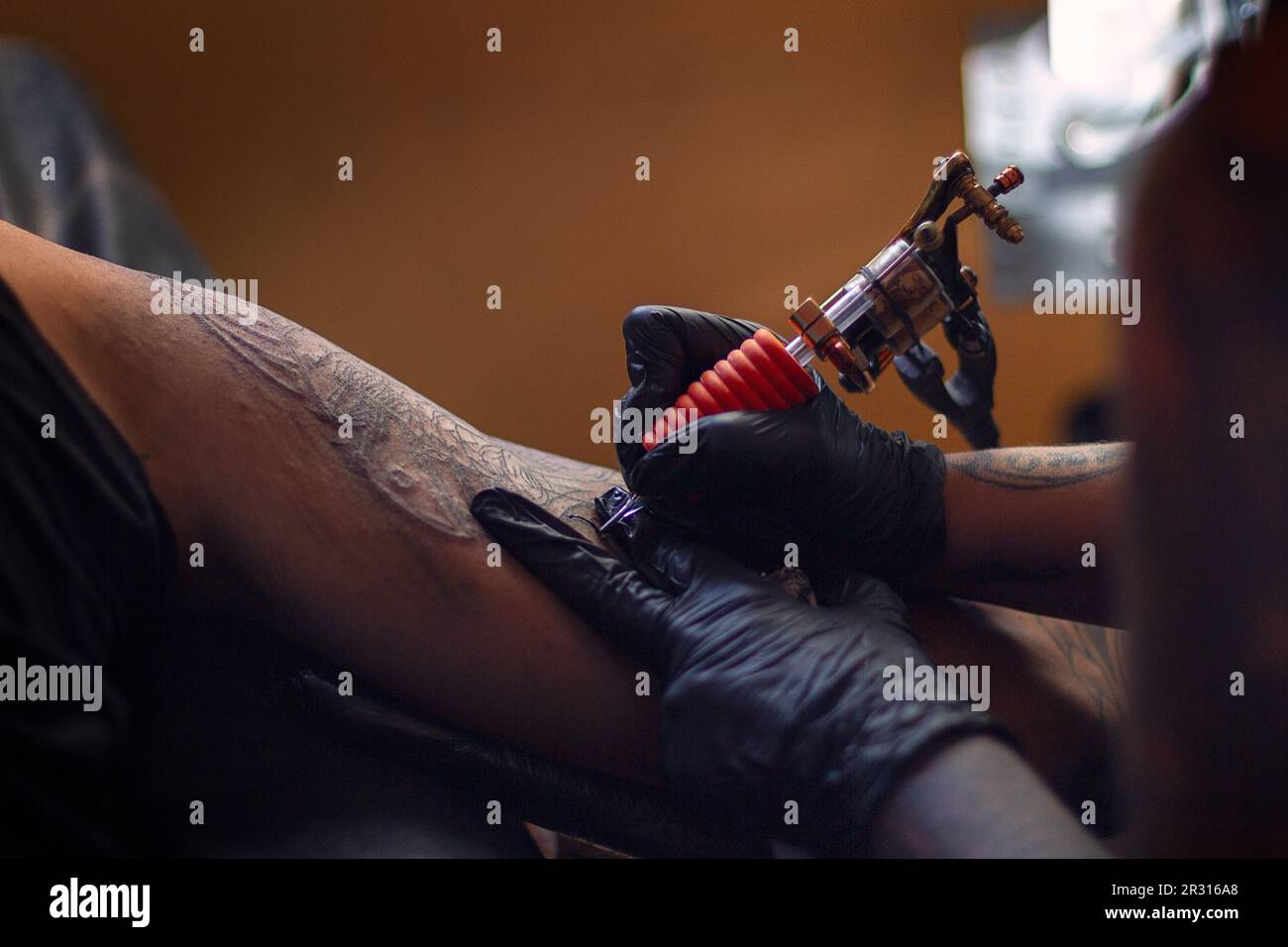 tatto artist tattooing a samurai to a white man Stock Photo