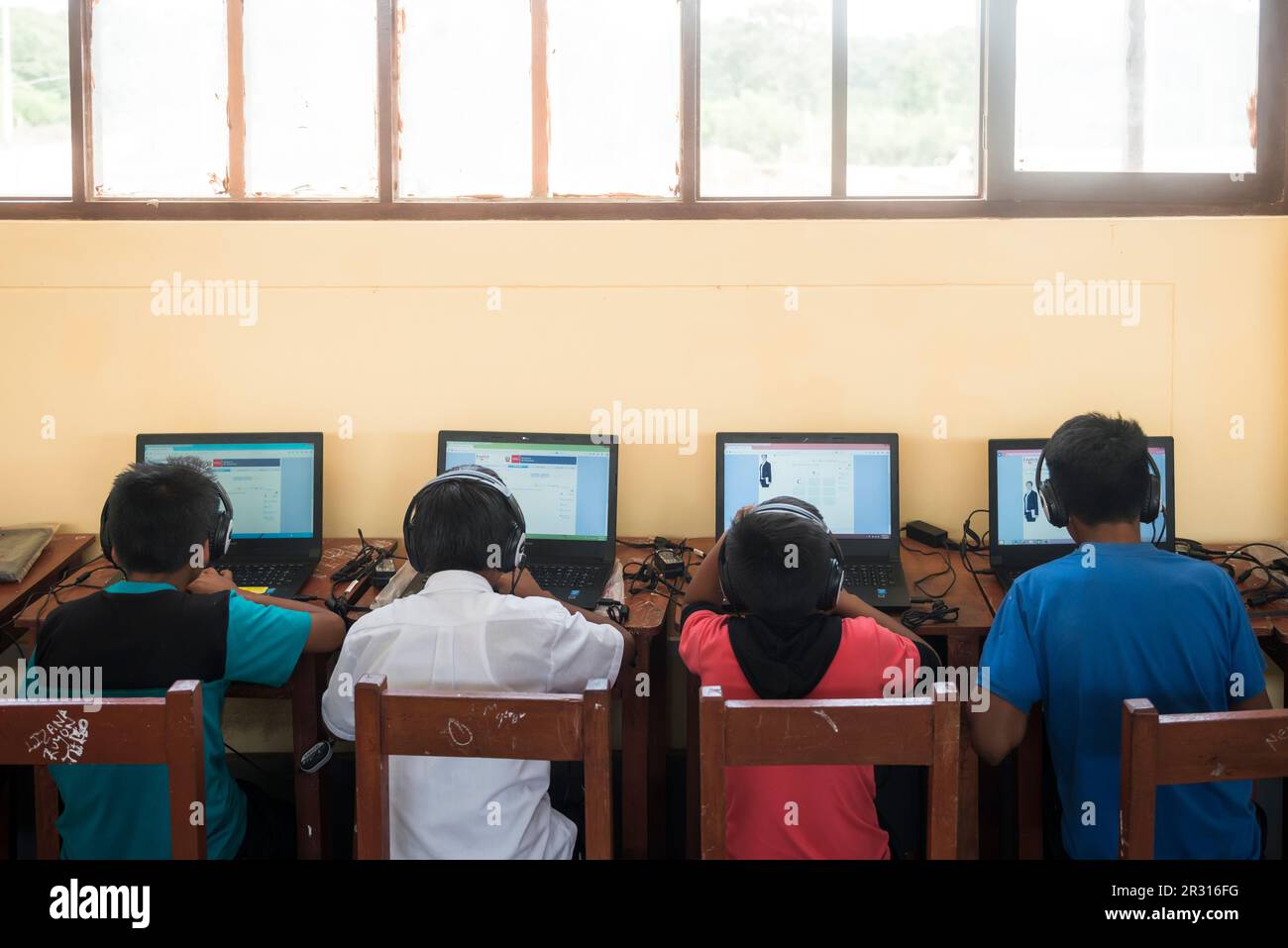 Peruvian children learning english using computers in a classroom Stock Photo