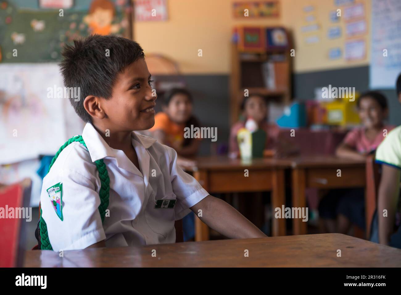 Peruvian boy paying attention to his teacher in the classroom Stock Photo