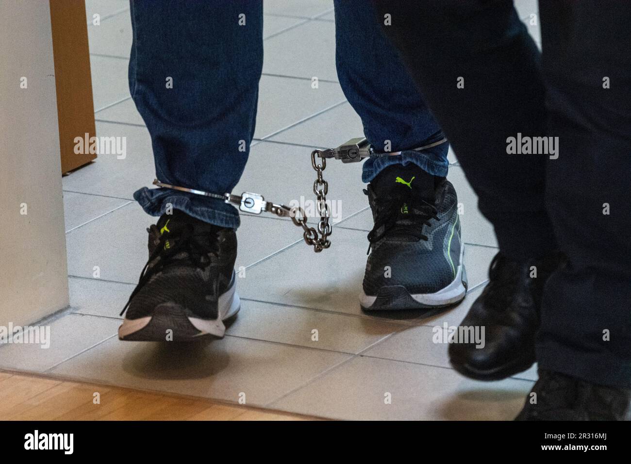 Stralsund, Germany. 22nd May, 2023. A defendant comes to the courtroom in the district court with shackles on his feet. The main hearing against the 46-year-old defendant for attempted murder, another attempted manslaughter and completed bodily injury offenses, each to the detriment of his divorced wife, begins at the Stralsund Regional Court. Credit: Stefan Sauer/dpa/Alamy Live News Stock Photo