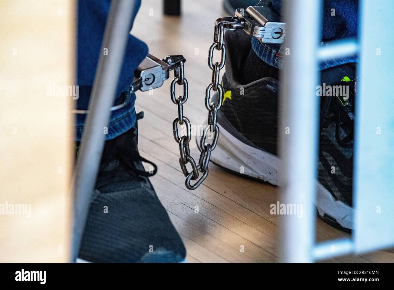 Stralsund, Germany. 22nd May, 2023. A defendant sits in the courtroom of the regional court with shackles on his feet. The main hearing against the 46-year-old defendant for attempted murder, another attempted manslaughter and completed bodily injury offenses, each to the detriment of his divorced wife, begins at the Stralsund Regional Court. Credit: Stefan Sauer/dpa/Alamy Live News Stock Photo