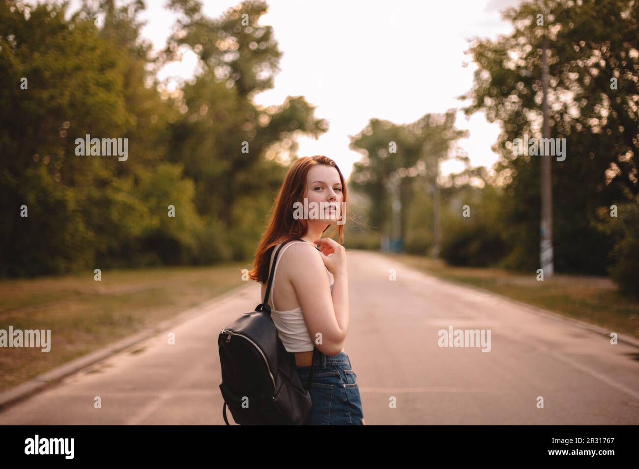 Young woman walking on country road Stock Photo