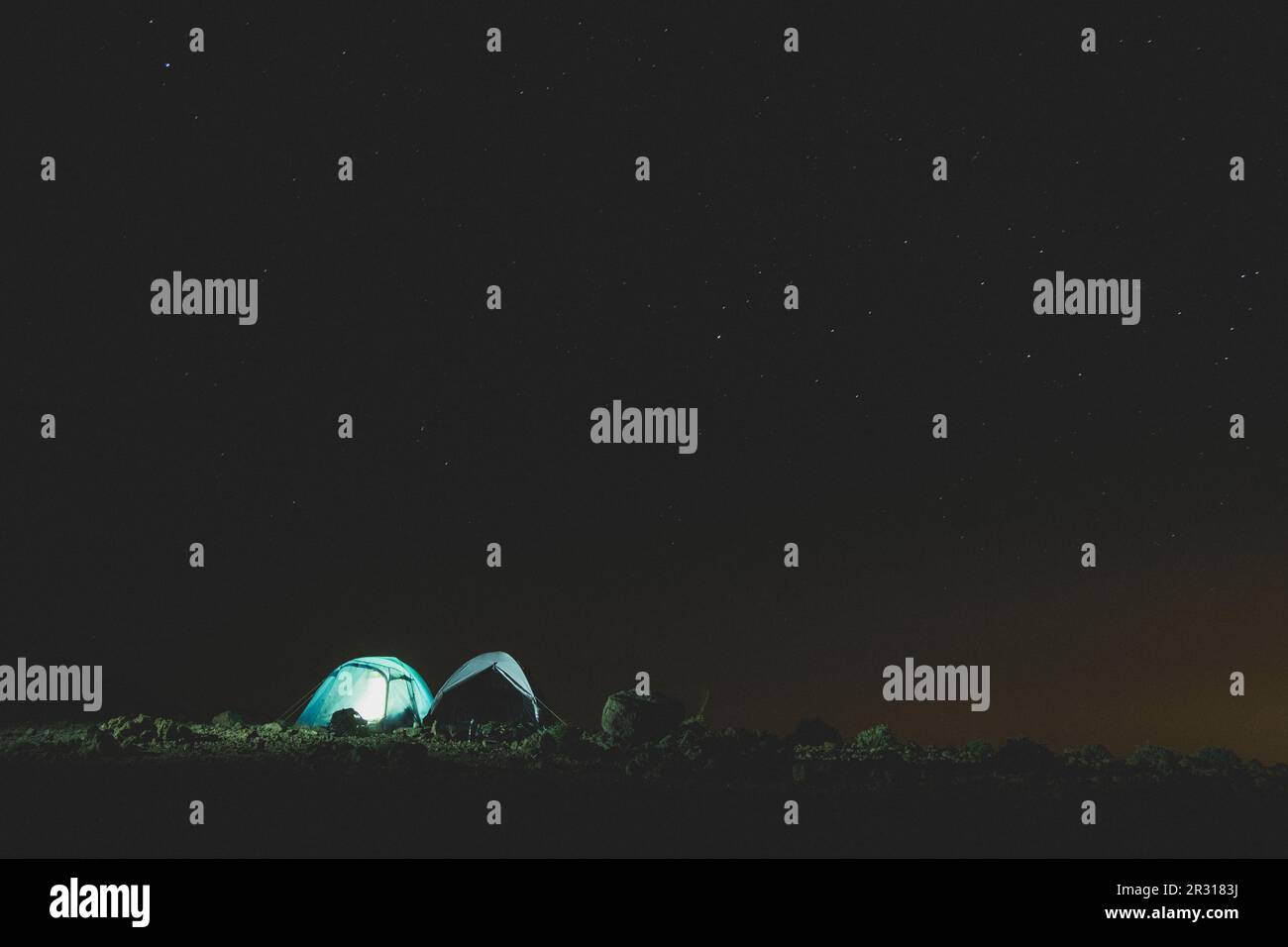 Two lit up tents at campsite under a starry sky Stock Photo - Alamy