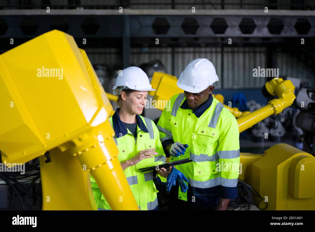 Engineer work at robotic arm factory. Technology and engineering concept. Stock Photo