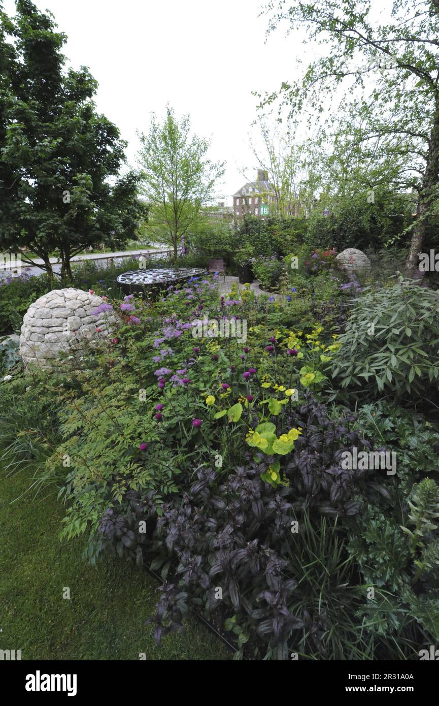 London, UK. 22nd May, 2023. Opening day at the 2023 Royal Horticultural Society Chelsea Flower Show - one of the Show Gardens on display: the Centrepoint Garden.  The garden is set against a ruinous house, where nature has taken over to begun to heal the scars. A mix of trees, shrubs, ferns, wildflowers and ‘so-called’ weeds show what might appear to be a dysfunctional space is in fact a thriving, natural and evolving habitat, emphasising the role a garden plays in making a house a home.  The tent in the shot was slept in overnight by Vicky Pattison (TV/media personality and author).  Chelsea  Stock Photo