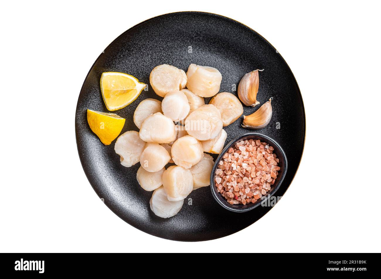 Raw sea scallops seafood on a plate with pink salt and lemon. Isolated on white background Stock Photo